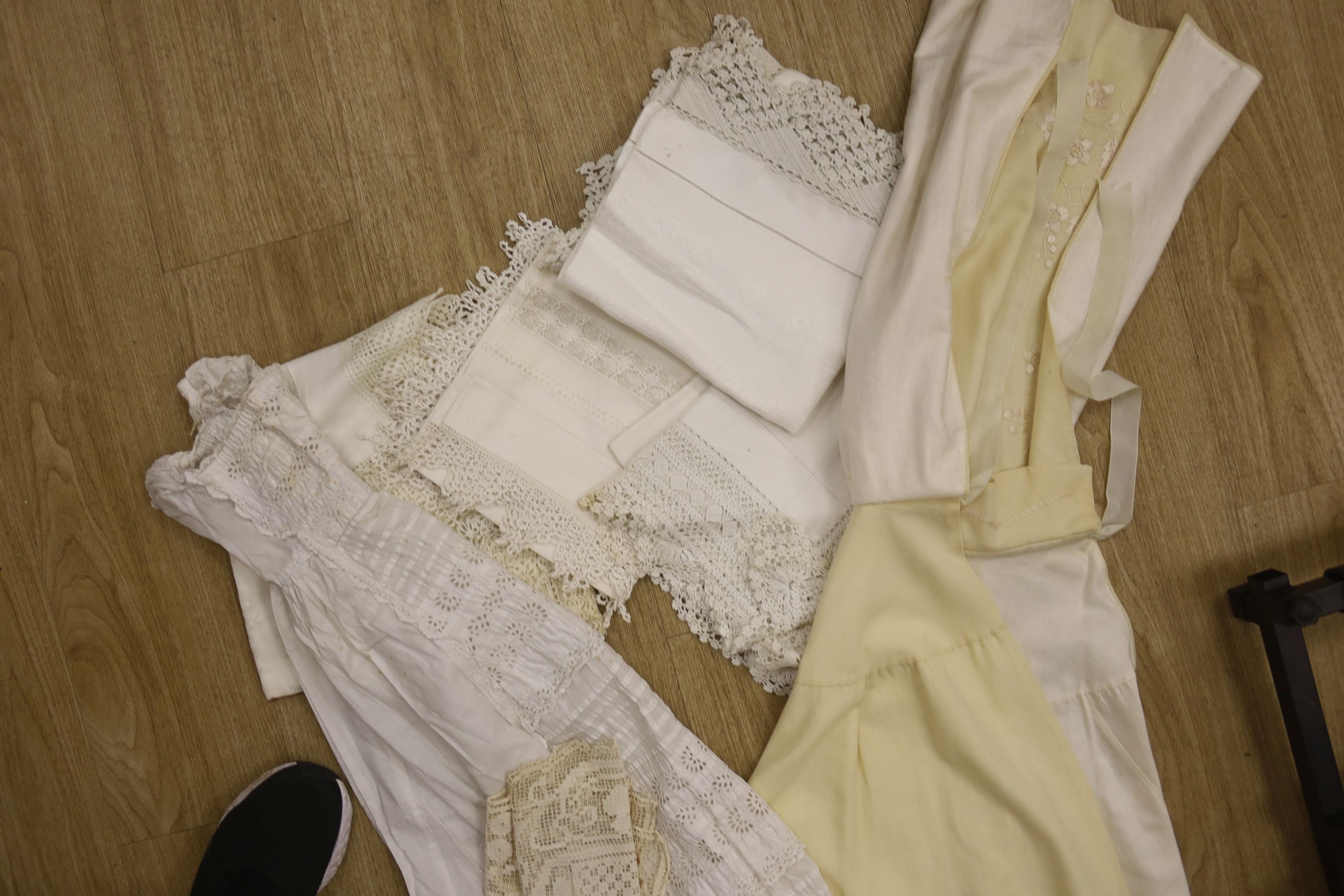 A 19th century embroidery anglais christening gown and nun's veiling cape, together with a small collection of tablecloths, etc